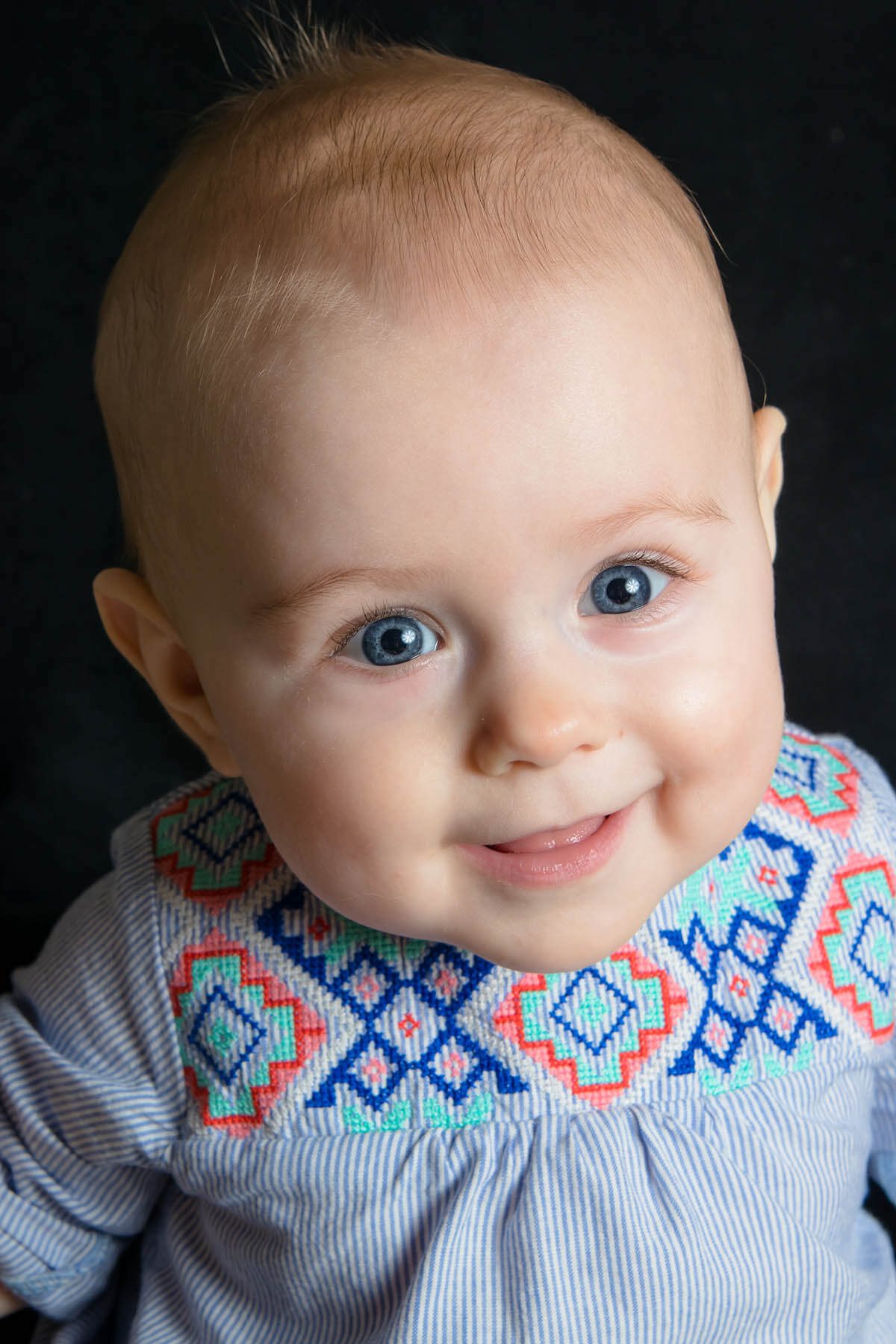 beautiful baby smiling with bright blue eyes